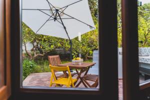 a table with a yellow chair and an umbrella at Il Limoneto Rooms in Terme Vigliatore