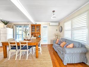 a kitchen and dining room with a table and a couch at Mermaid Cottage at Hyams Beach in Hyams Beach