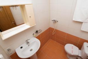 a bathroom with a sink and a toilet at Elena Studios in Athani