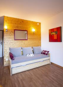 Cama en habitación con pared de madera en Le Hameau SPA & PISCINE studio 4pers by Alpvision Résidences, en Orelle