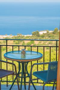a table and chairs on a balcony with a view at Elena Studios in Athani