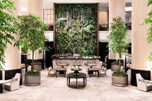 a lobby with tables and chairs and plants at Shangri-La Singapore in Singapore