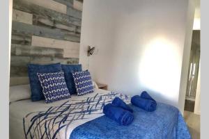 sypialnia z łóżkiem z niebieską pościelą i poduszkami w obiekcie MIRADOR Sea View apartment w mieście Calpe