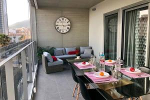 stół i krzesła na balkonie z zegarem w obiekcie MIRADOR Sea View apartment w mieście Calpe