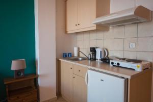 a kitchen with a counter top with a sink and a stove at Elena Studios in Athani