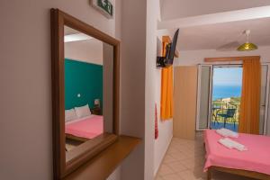 a mirror in a room with a bed and a balcony at Elena Studios in Athani