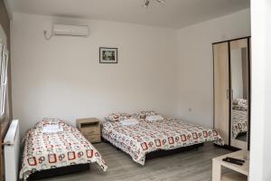 a bedroom with two beds and a mirror at CITY APARTMENT BB in Bajina Bašta