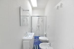 ein weißes Bad mit einem WC und einem Waschbecken in der Unterkunft Il marchese in piscina in San Pietro in Bevagna
