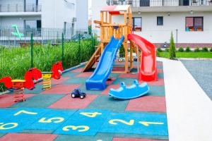 um parque infantil com escorrega e brinquedos num passeio em Vila Kos em Mamaia Nord – Năvodari