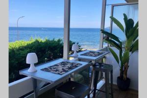 2 tafels op een balkon met uitzicht op de oceaan bij Charmant studio avec terrasse vue mer à 50 m in Sainte-Maxime