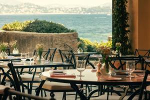 a group of tables and chairs with the ocean in the background at Hotel la Ponche in Saint-Tropez