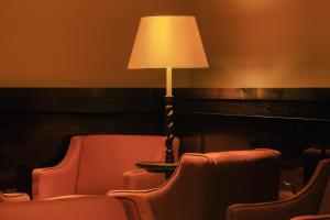 a lamp sitting next to two chairs and a table at Hotel la Ponche in Saint-Tropez
