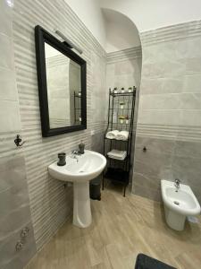 a bathroom with a sink and a mirror and a toilet at Nammuratè - Casa Vacanze in Naples