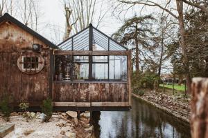 uma casa de vidro ao lado de um rio em Cabane ForRest Glace, près de Lyon et Clermont em Lay
