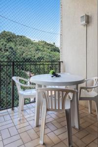 - Balcón con mesa blanca y sillas en Residence Real Copacabana, en Río de Janeiro