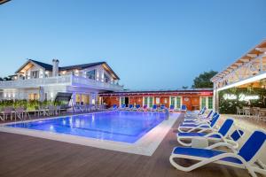 uma piscina de resort com espreguiçadeiras e um hotel em Villa Bianca em Rubjekë