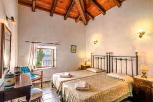 Un dormitorio con una cama y un escritorio y una ventana. en Villa Lithari, Nissaki, Corfu, en Vlikatsoúri