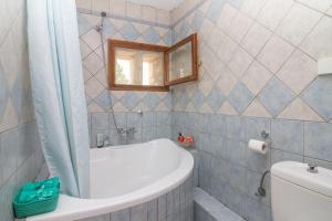 y baño con bañera, aseo y espejo. en Villa Lithari, Nissaki, Corfu, en Vlikatsoúri 21 fotos más