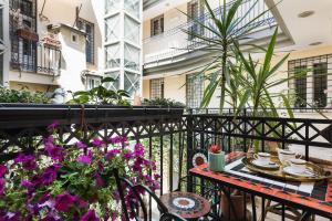 a balcony with a table and chairs and flowers at Idyllia - Colosseum luxury apartment in Rome