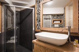 a bathroom with a white sink and a shower at Idyllia - Colosseum luxury apartment in Rome