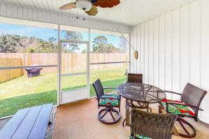 a screened in porch with a table and chairs at Gulf Breeze Cottage in Perdido Key
