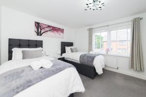 a bedroom with two beds and a window at Greenfield Modern 3BR Home - Southcote lane , Reading in Reading