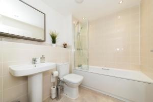 une salle de bain avec un lavabo, des toilettes et une baignoire dans l'établissement Greenfield Modern 3BR Home - Southcote lane , Reading, à Reading 35 autres photos
