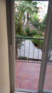 an open door to a balcony with a cat looking out at Habitación independiente céntrica in Fuengirola