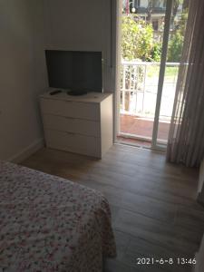 Dormitorio con cama y tocador con TV en Habitación independiente céntrica, en Fuengirola