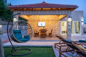 a patio with a chair and a swing at Villa Pajkan in Dubrovnik
