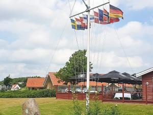two flags on a pole in a yard at 8 person holiday home in Egernsund in Egernsund