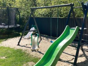 einen Spielplatz mit zwei Schaukeln und einer Rutsche in der Unterkunft 8 person holiday home in Oksb l in Øster Vrøgum