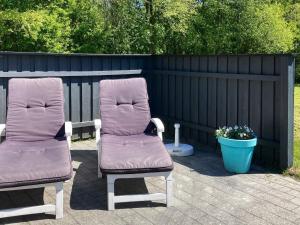 zwei Stühle auf einer Terrasse neben einem Zaun in der Unterkunft 8 person holiday home in Oksb l in Øster Vrøgum