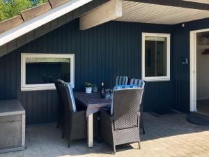 eine Terrasse mit einem Tisch und Stühlen auf einer Veranda in der Unterkunft 8 person holiday home in Oksb l in Øster Vrøgum