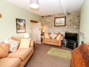 a living room with a couch and a television at Hury Lodge in Hury