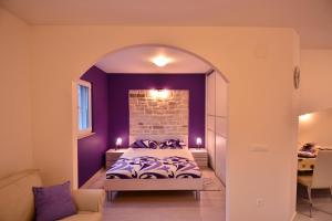 een slaapkamer met een bed en een bakstenen muur bij Apartment Scents of Dubrovnik in Dubrovnik