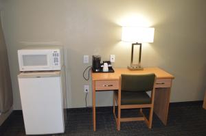 escritorio con microondas, lámpara y nevera en Budget Inn, en Paso Robles