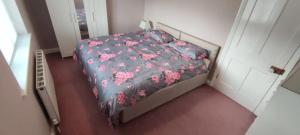 a small bedroom with a bed with pink flowers at Great base for a Yorkshire adventure in Old Malton