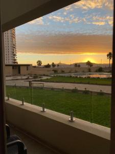 a window with a view of a field from a building at Bello departamento av del mar in Coquimbo