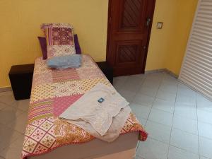 a bedroom with a bed with a quilt on it at Pousada Exuberance in Diadema