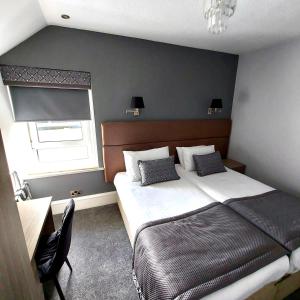 a bedroom with a large bed and a window at Newmachar Hotel in Newmacher