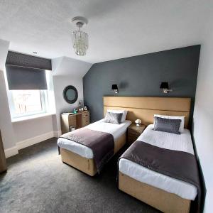 a bedroom with two beds and a chandelier at Newmachar Hotel in Newmachar