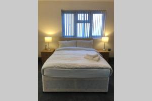 um quarto com uma cama grande e 2 candeeiros em Cozy self contained apartment em Birmingham