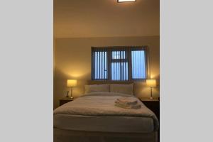 um quarto com uma cama com 2 candeeiros e uma janela em Cozy self contained apartment em Birmingham