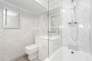 een witte badkamer met een toilet en een douche bij Royal Mile Old Town Apartment in Edinburgh