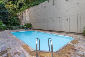 a swimming pool in a backyard with a wooden wall at Residence Real Copacabana in Rio de Janeiro