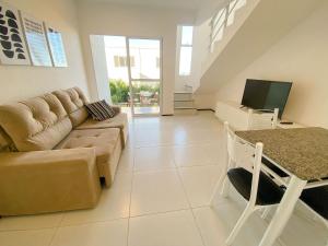 a living room with a couch and a table at Beach Townhouses I por Be My Guest in Aquiraz