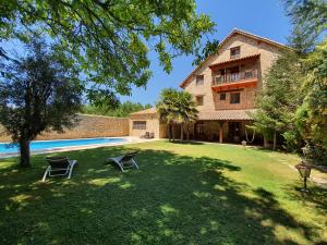 a large yard with two chairs in front of a house at Tierras de Moya in Los Huertos