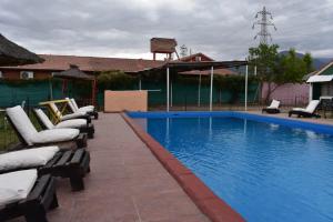
a pool with a pool table and chairs in it at Complejo Solitudine in Cacheuta
