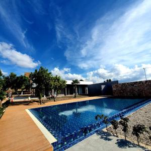 - une piscine dans une cour avec un ciel bleu dans l'établissement Kambaniru Beach Hotel and Resort, à Waingapu
